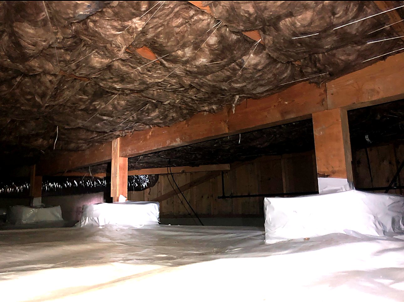Wide crawl space finished with insulation and ground cover
