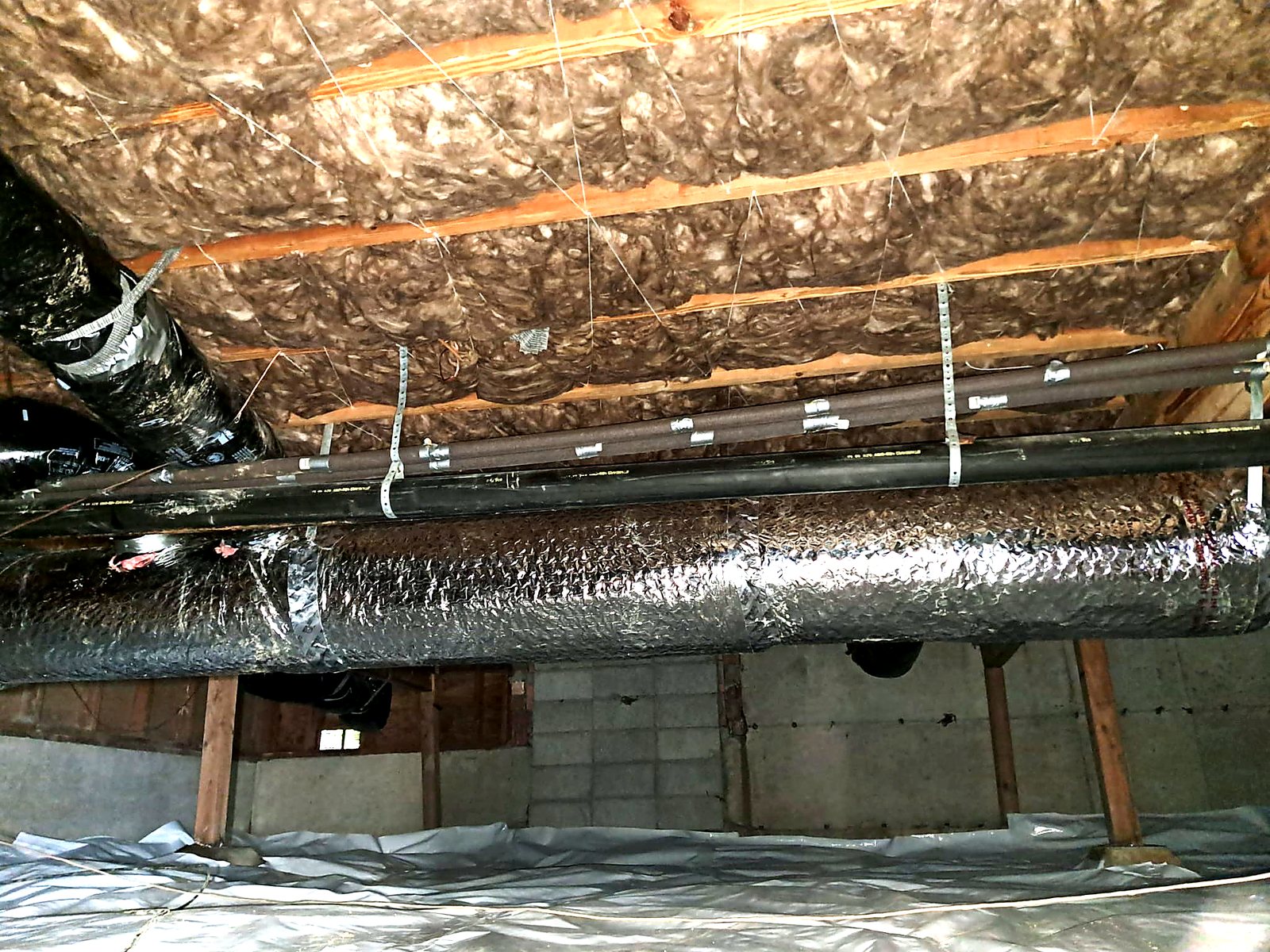 Insulated ductwork above a new crawl space ground cover