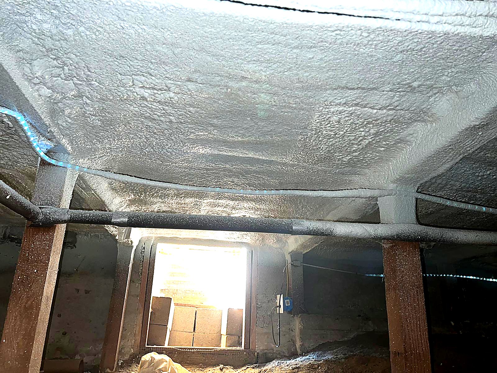 Spray-applied insulation under a crawl space floor