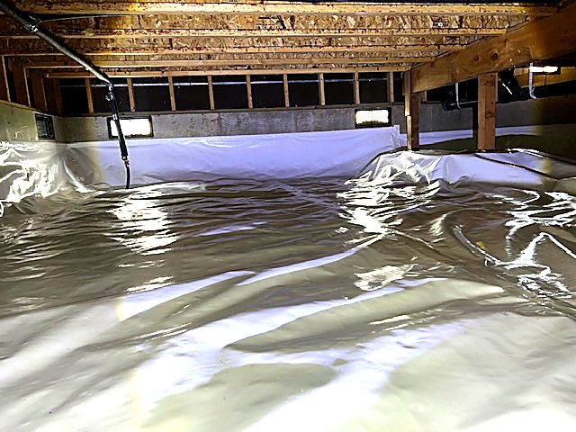 Reflective vapor barrier sealed across the crawl space floor